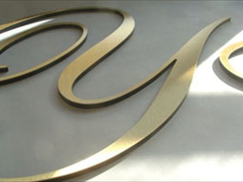 laminated letters with polished brass face in script font